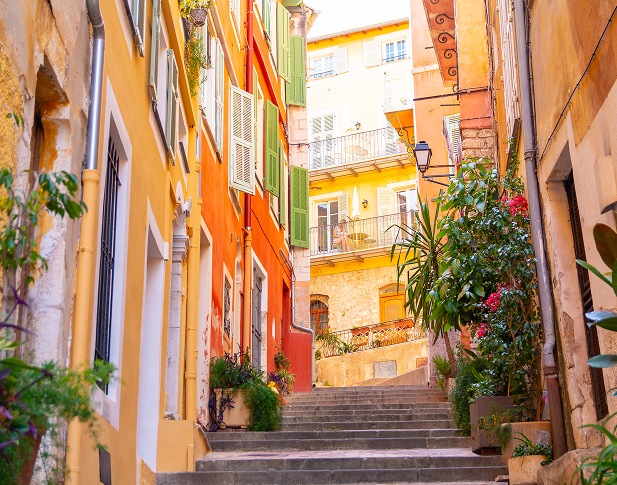 Ruelle colorée avec escaliers et façades méditerranéennes ensoleillées