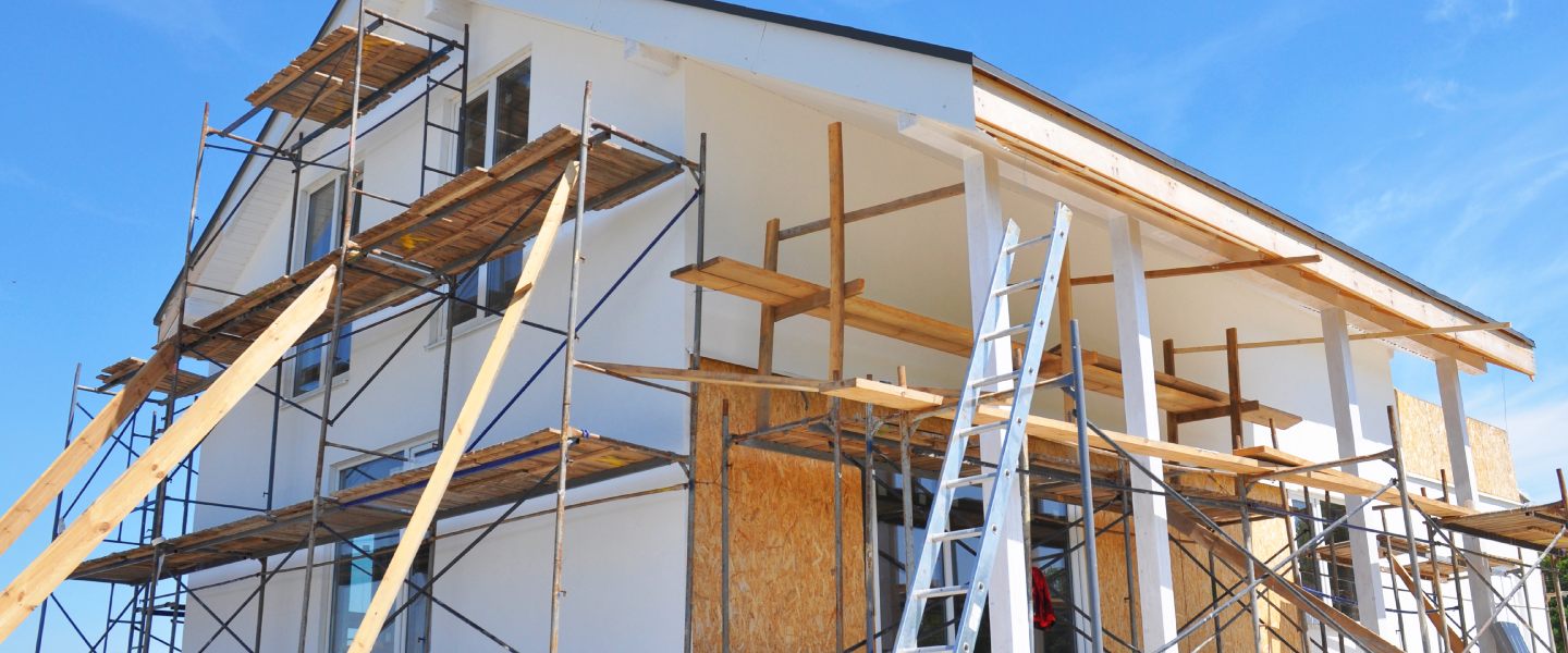 Maison en construction avec échafaudages et travaux de rénovation extérieure