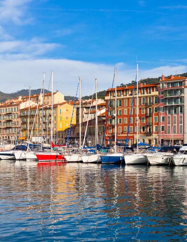 Port de plaisance avec voiliers et bâtiments colorés en bord de mer